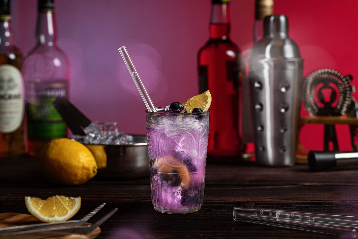 Pailles en verre réutilisables HALM dans un verre avec une boisson Blueberry Spritz rafraîchissante et des myrtilles.