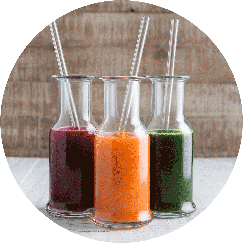 Pailles en verre HALM réutilisables dans un verre avec du jus vert, alternative durable aux pailles en plastique