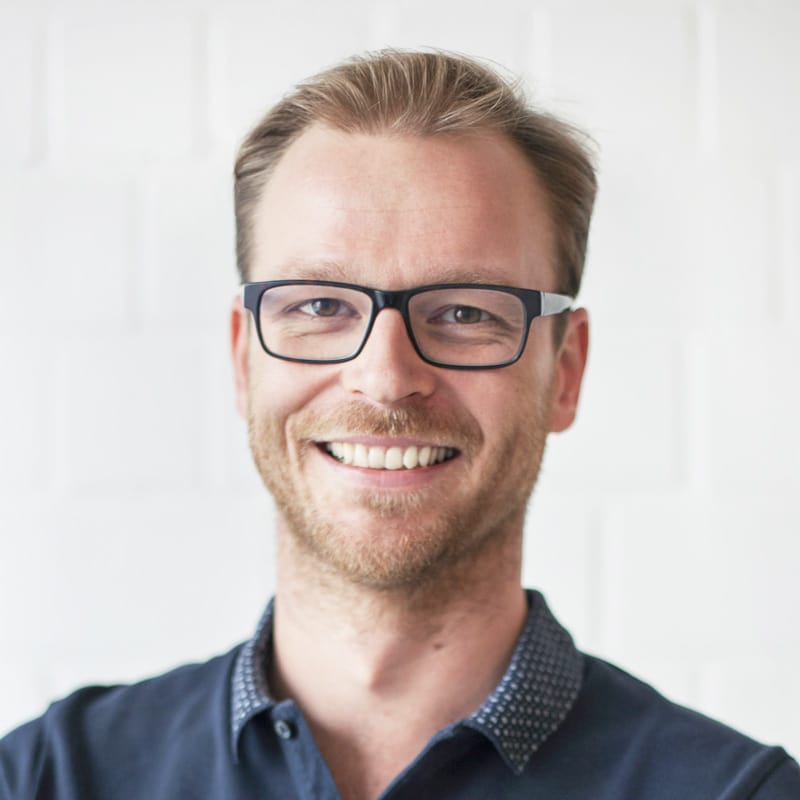 Portrait du cofondateur de HALM, Sebastian Müller, avec des pailles en verre écologiques et réutilisables.