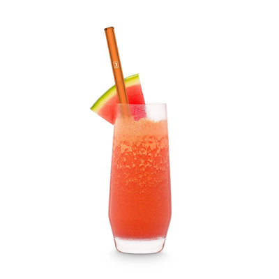 Wiederverwendbare neonorange Glasstrohhalme von HALM in einem Glas mit Wassermelonensaft
