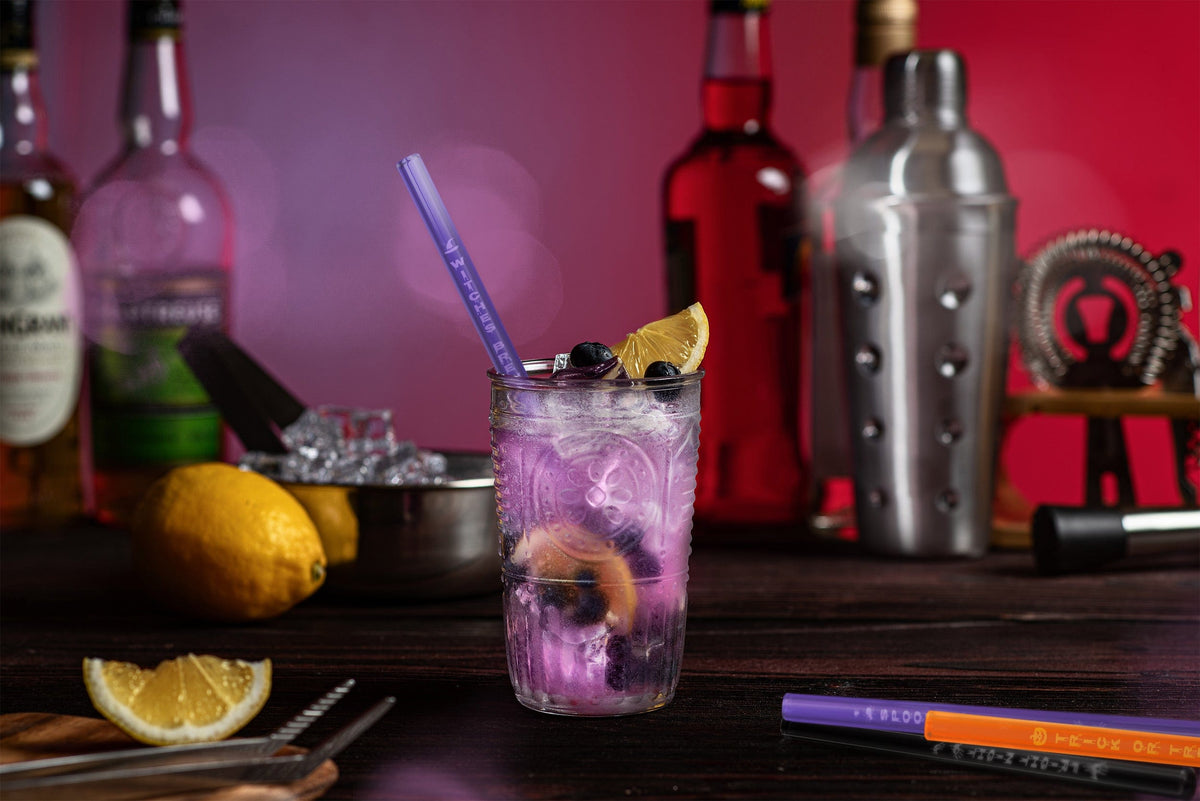 Ein 20 cm langer, beerenfarbener HALM Glasstrohhalm in einem Glas mit einem erfrischenden Spritz-Getränk, Beeren und Minze – nachhaltig und wiederverwendbar.