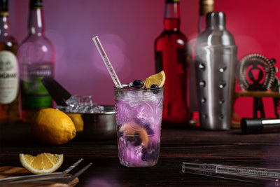 Wiederverwendbare HALM Glasstrohhalme in einem Glas mit einem Blueberry Spritz Cocktail.